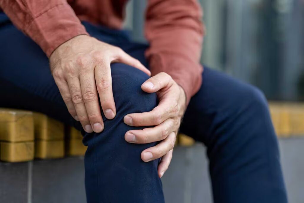 close up of person holding knee in pain wearing ca 2026 01 09 07 43 47 utc converted